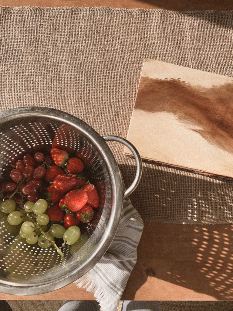 Strawberries and grapes in colander. 