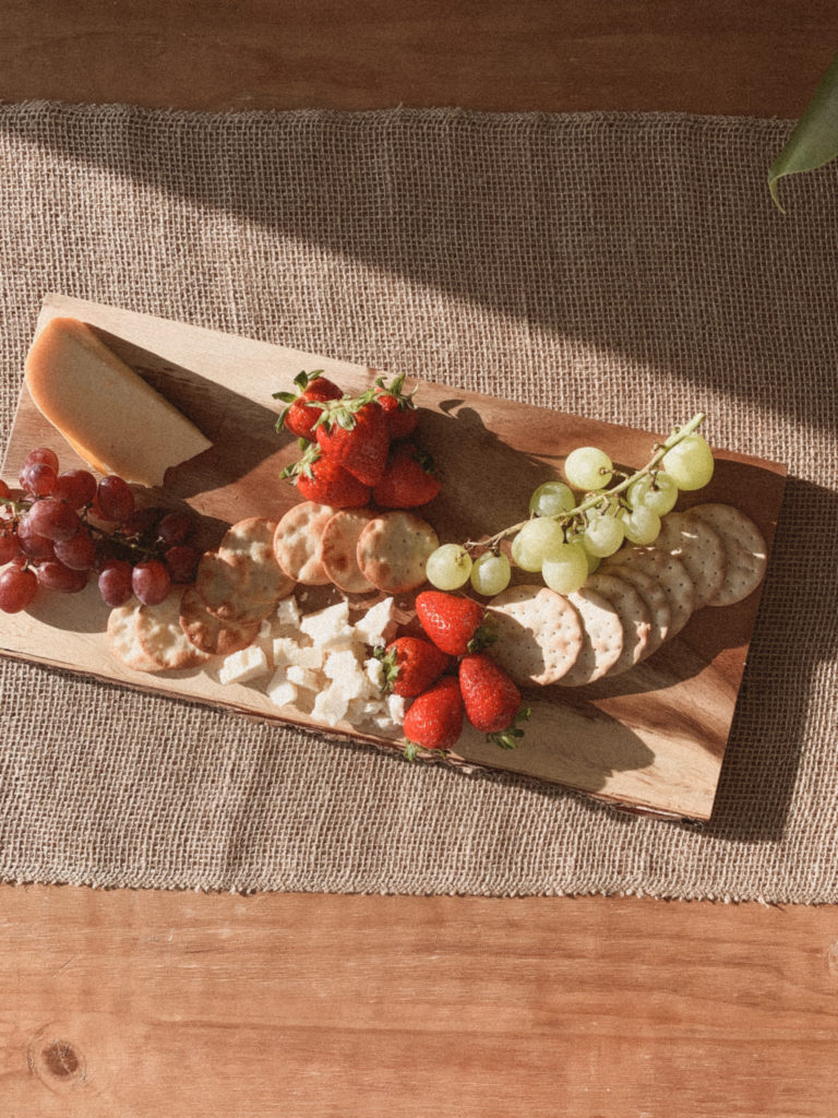 Cheeses now arranged on the cheeseboard, in addition to fruits and crackers. 