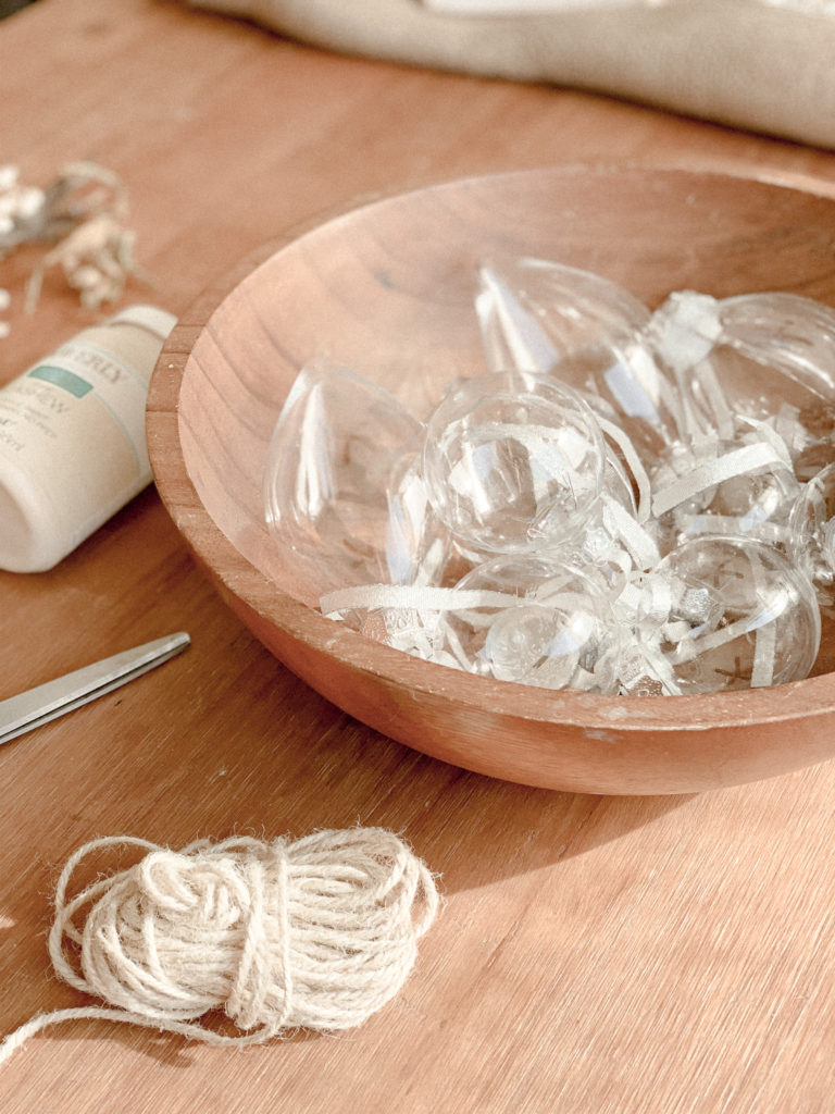 Bowl of plastic ornaments on table with twine. 