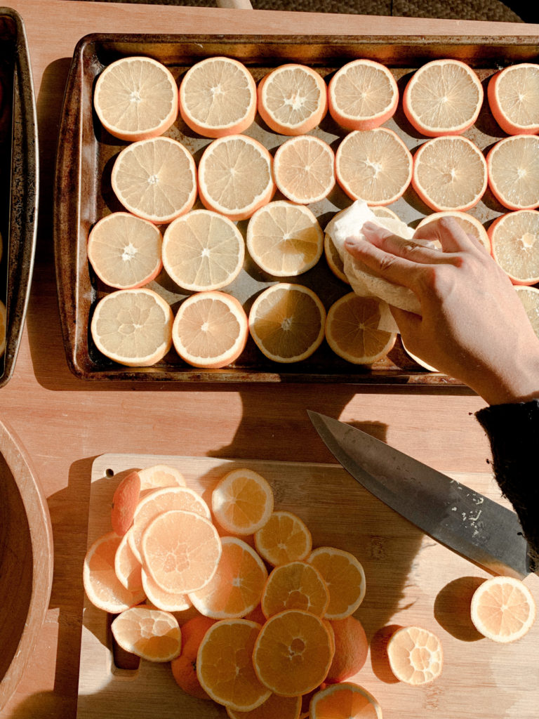 Overhead shot of dabbing paper towel on orange slices. 