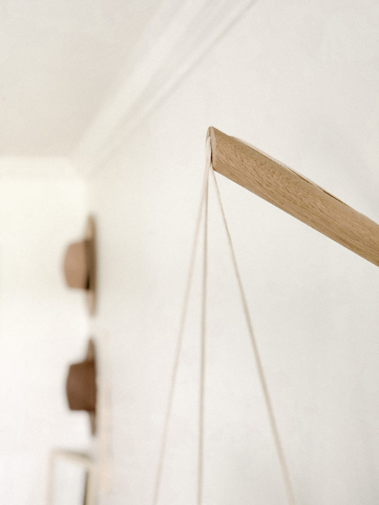 Close up of wooden dowel mount of hanging planter.
