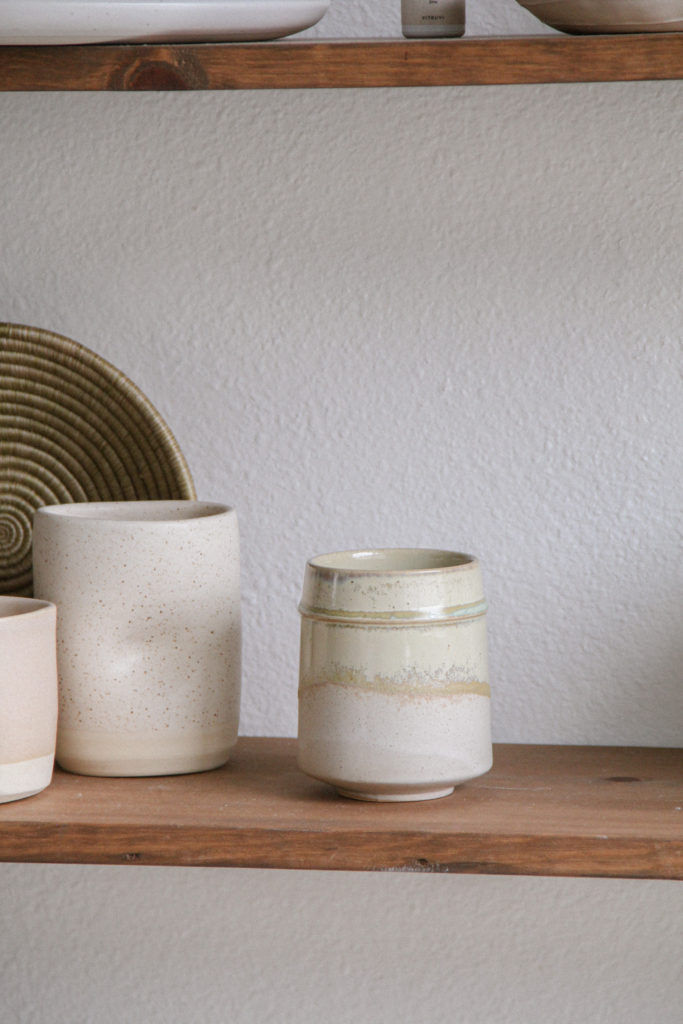 Ceramic mug on wood styled shelves. 