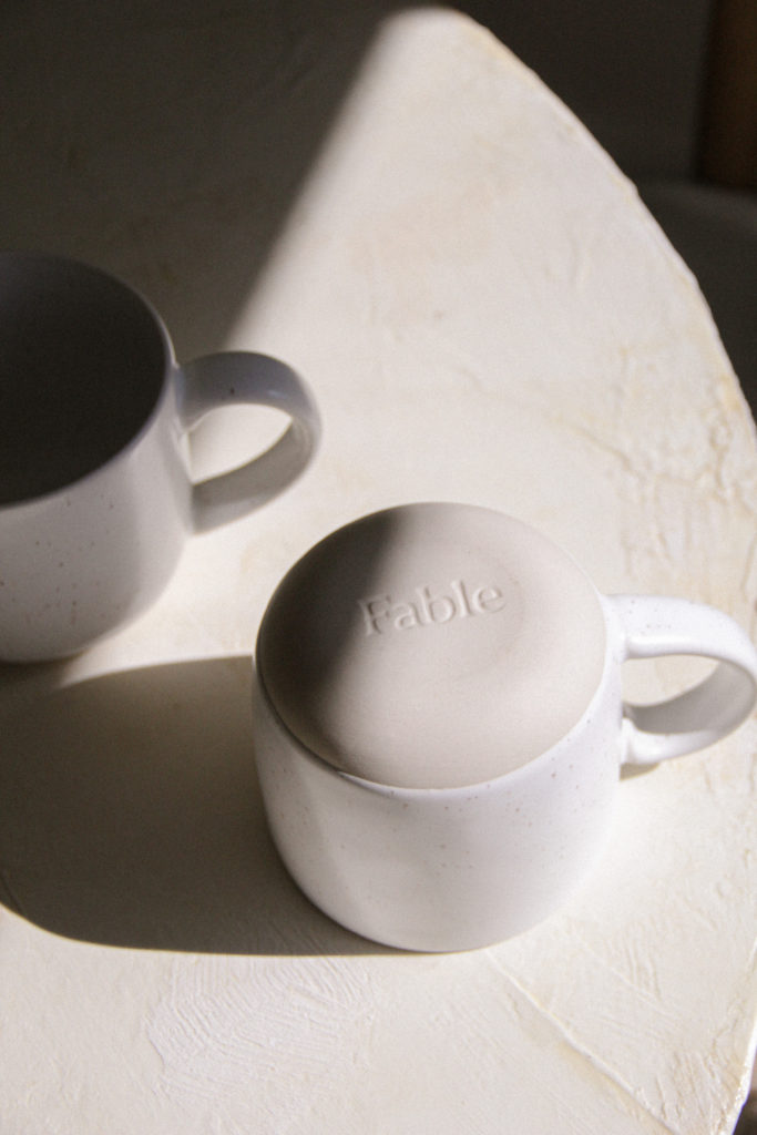 Bottom of Fable dinnerware cup, stamped with "Fable" logo. 